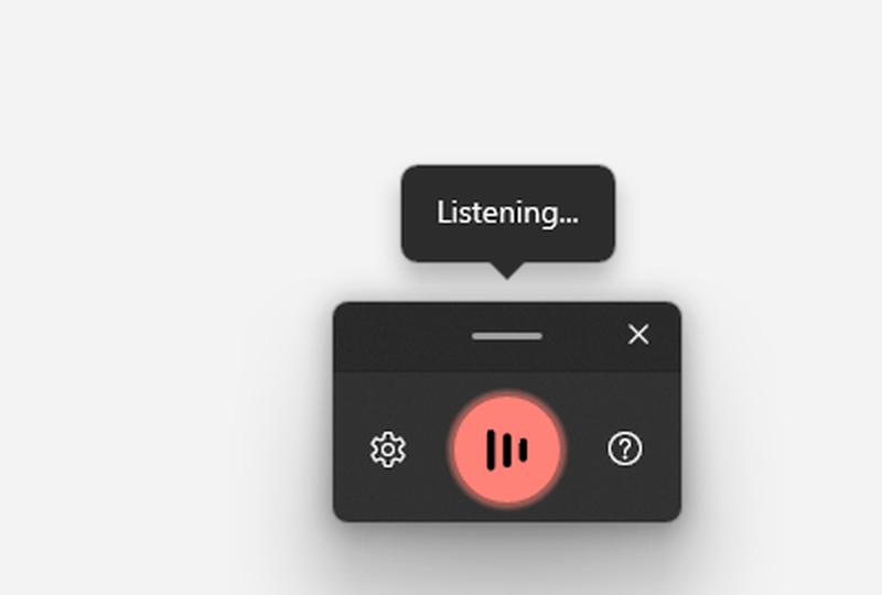 The Windows 11 voice typing launcher while listening: a lit microphone button, a Listening tip above it, and a gear button